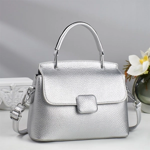 Silver pebbled leather trapezoid handbag with top handle and adjustable shoulder strap