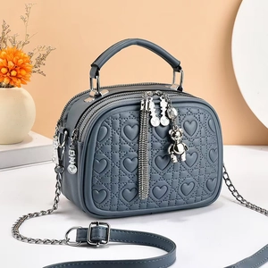 Blue-grey heart-quilted crossbody bag with bear pendant and dual zippers for women