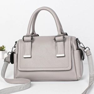 Detail view of grey pebble leather Boston bag with wide woven strap and metal hardware
