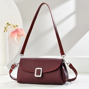 Chic wine red woven crossbody handbag for women with silver lock on a minimalist stand