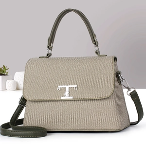 Dettaglio della borsa strutturata in tessuto beige con finiture in pelle verde oliva e logo T