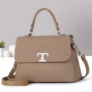 Borsa a tracolla intrecciata marrone con finiture in pelle e fibbia argentata in stanza minimal