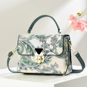 Retro paisley print crossbody handbag with green leather handles and gold rotating lock