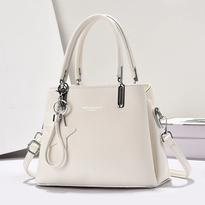 Detail of white lychee pattern leather handbag with silver hardware and star charm accessory