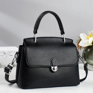 Elegant black lychee leather handbag with silver twist lock and crossbody strap