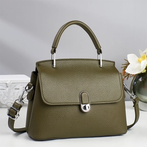 Detail of olive green textured leather handbag with silver twist lock and handle