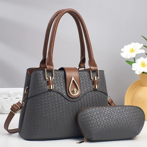 Detail of grey textured tote bag with brown handles and matching smaller pouch