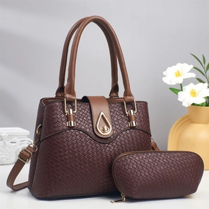 Detail of dark brown woven leather tote and matching pouch set with golden hardware