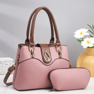 Detail of pink lizard texture tote and clutch set with gold teardrop metal buckle hardware