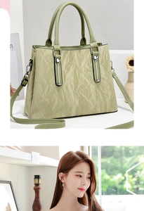 Detail of light green pleated handbag showing soft texture and detachable shoulder strap