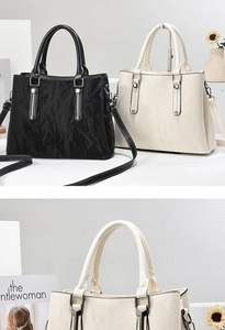 Close-up of black and beige textured leather tote bags with elegant silver metal accents