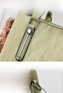 Detail of light green faux leather tote with vintage pleated texture and silver hardware