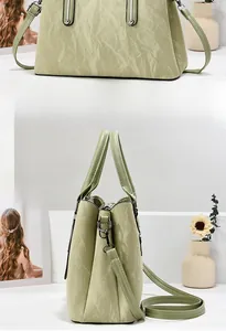 Front and side view of light green pleated texture handbag with detachable shoulder strap