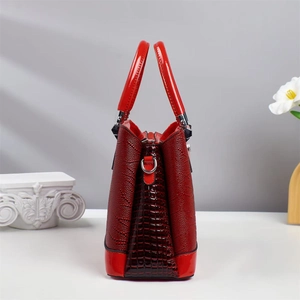 Détails d'un sac à main rouge avec gaufrage crocodile et motifs floraux en relief chic