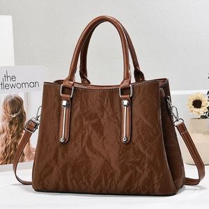 Brown textured leather tote bag with dual handles and adjustable strap for women