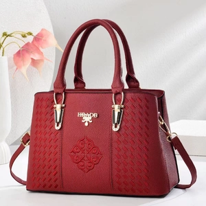 Detail of red leather handbag with geometric embroidery and gold HRADB metal logo