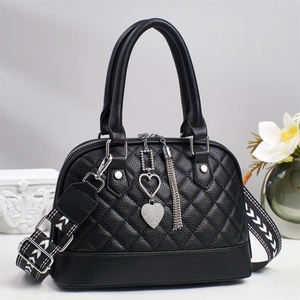 Elegant black quilted shell-shaped handbag with geometric wide strap and silver heart charm