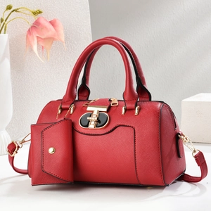 Red large capacity Boston handbag with gold hardware and small pouch on marble background