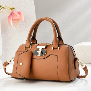Close-up of tan Saffiano leather handbag featuring a golden geometric turn-lock and hardware