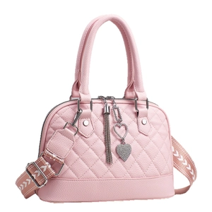 Pink quilted shoulder bag with heart strap and tassel charm on a white background