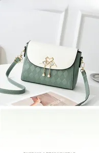 Detail of sage green quilted crossbody bag with golden swan buckle and pearl charm