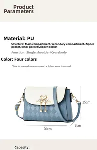 Detail view of bicolor crossbody bag showing swan buckle, pearl tassels, and PU texture