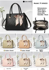 Detail view of woven leather handbag featuring multiple compartments and ribbon decoration