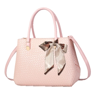 Elegant light pink handbag with woven texture and decorative ribbon on handle