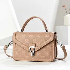 Detail of light khaki handbag featuring embossed houndstooth texture and silver buckle