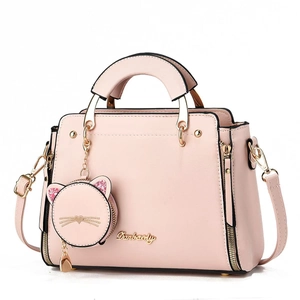 Detail of pink leather handbag with cat-shaped coin purse and gold twist lock closure
