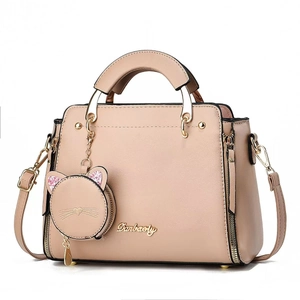 Elegant pink handbag with cute cat pendant and adjustable strap in a clean frontal view