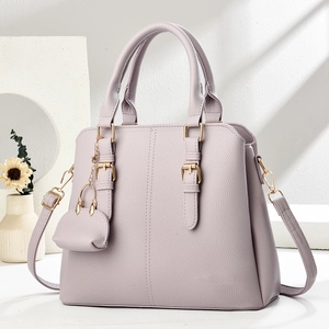 Lilac lychee leather tote bag with gold hardware and mini pouch charm in studio setting