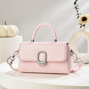 Detail of light pink square crossbody bag with silver metal ring and smooth leather texture