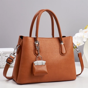 Détail du sac à main marron avec texture gaufrée et finitions métalliques argentées