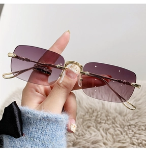 Détail de lunettes de soleil carrées sans monture avec verres violets dégradés dorés