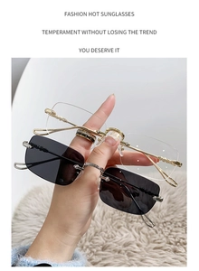 Détail de lunettes de soleil carrées sans monture avec branches en métal doré
