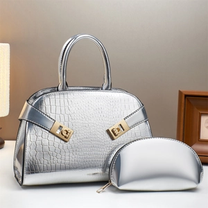 Silver crocodile textured handbag set with golden buckles in a warm interior setting