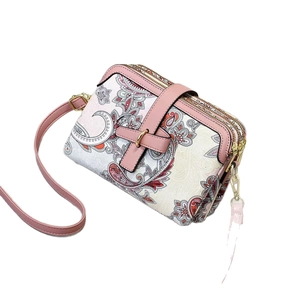 Pink paisley fabric crossbody bag with triple zippers and adjustable shoulder strap