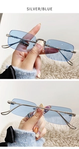 Détail de lunettes de soleil argentées sans monture avec verres bleus et branches gravées