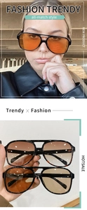 Detail of oversized retro oval sunglasses featuring vintage black frames and tinted ocean lenses