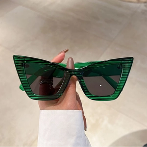 Detailed view of green transparent cat eye sunglasses with textured striped frames