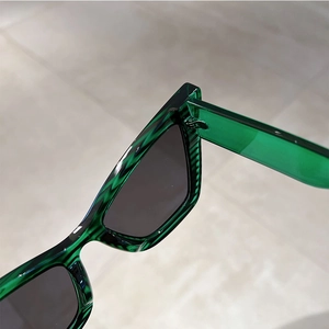 Detail of vintage cat-eye sunglasses featuring translucent green tortoiseshell frames