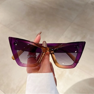 Close-up of cat-eye sunglasses with purple gradient frames on marble background