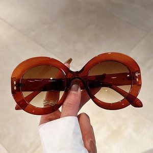 Detail of oversized round tortoiseshell sunglasses with metal rivets and gradient lenses