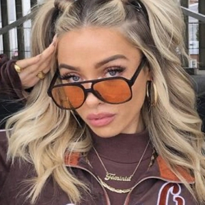 Fashionable oval retro sunglasses with vibrant orange lenses and a glossy black frame