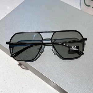 Detail of photochromic aviator sunglasses with black metal double bridge on marble