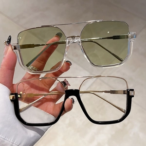 Close-up of semi-rimless square sunglasses with gold metal trim and black frame detail