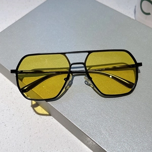 Detail of yellow aviator lenses with metal frame and nose pads on a display box