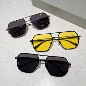 Detailed view of three vintage aviator sunglasses with metal frames on a stone surface
