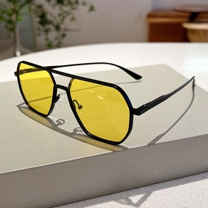 Detail of vintage aviator sunglasses with black metal frame and yellow lenses